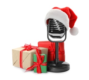 Photo of Retro microphone with Santa hat and gift boxes on white background. Christmas music