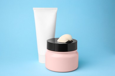 Photo of Cosmetic products and shell on light blue background
