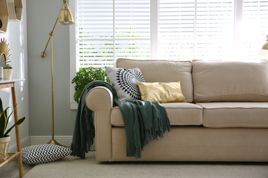 Photo of Stylish beige sofa in modern living room interior