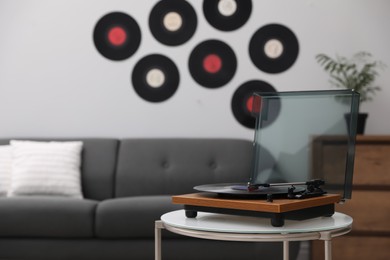 Stylish turntable with vinyl disc in living room