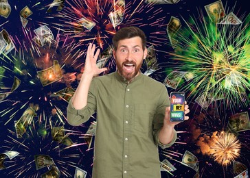 Image of Your Bet Wins! Emotional man holding smartphone under money shower against background with fireworks