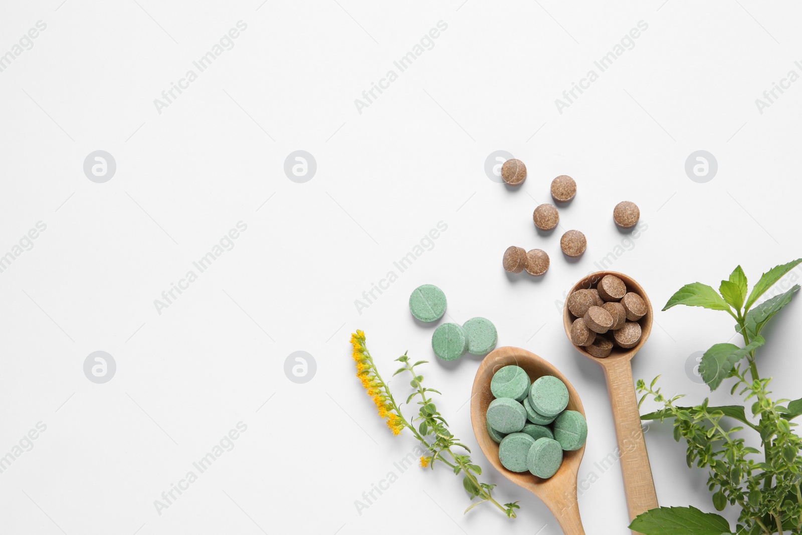 Photo of Different pills and herbs on white background, flat lay with space for text. Dietary supplements