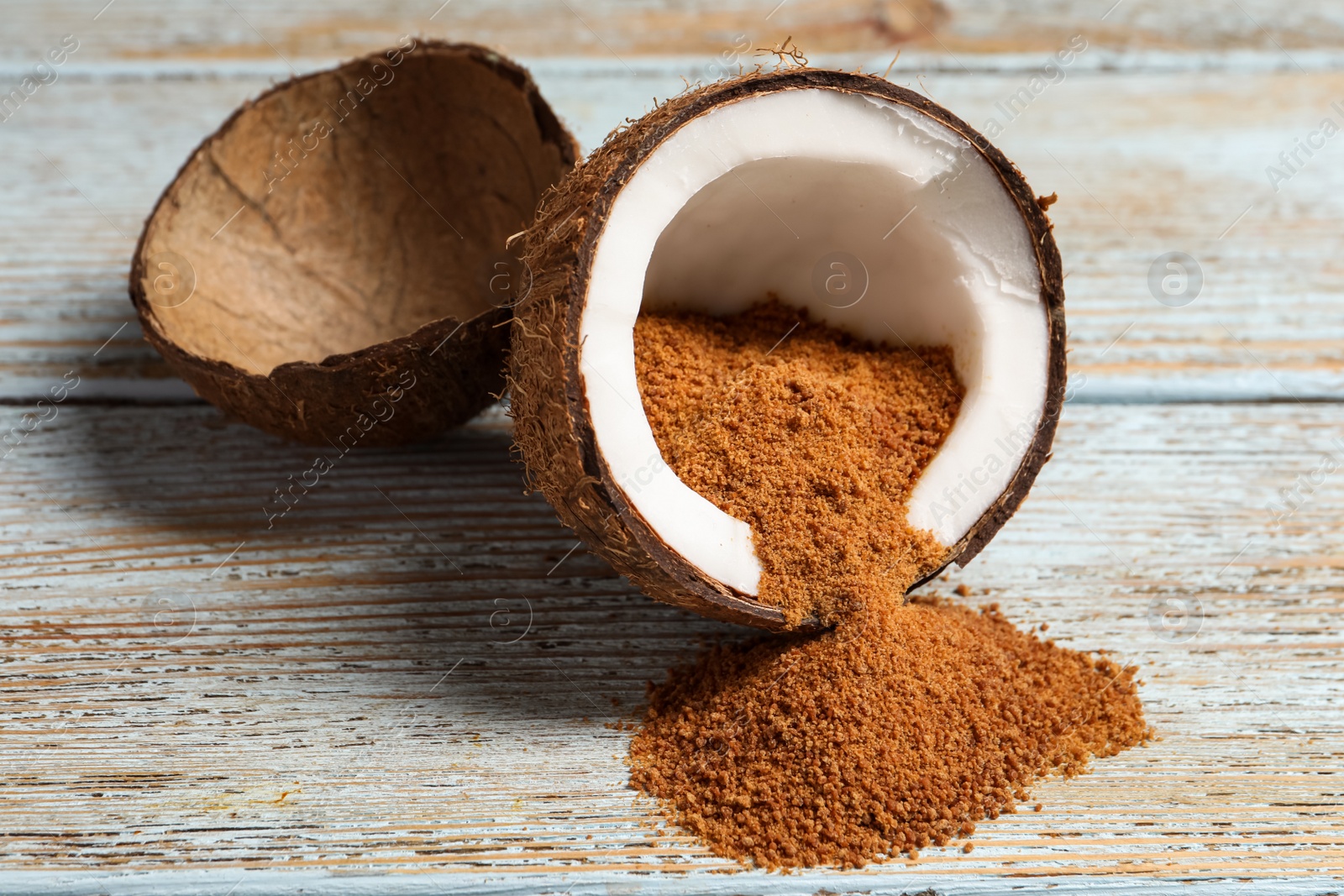 Photo of Ripe coconut with natural brown sugar on rustic table, closeup