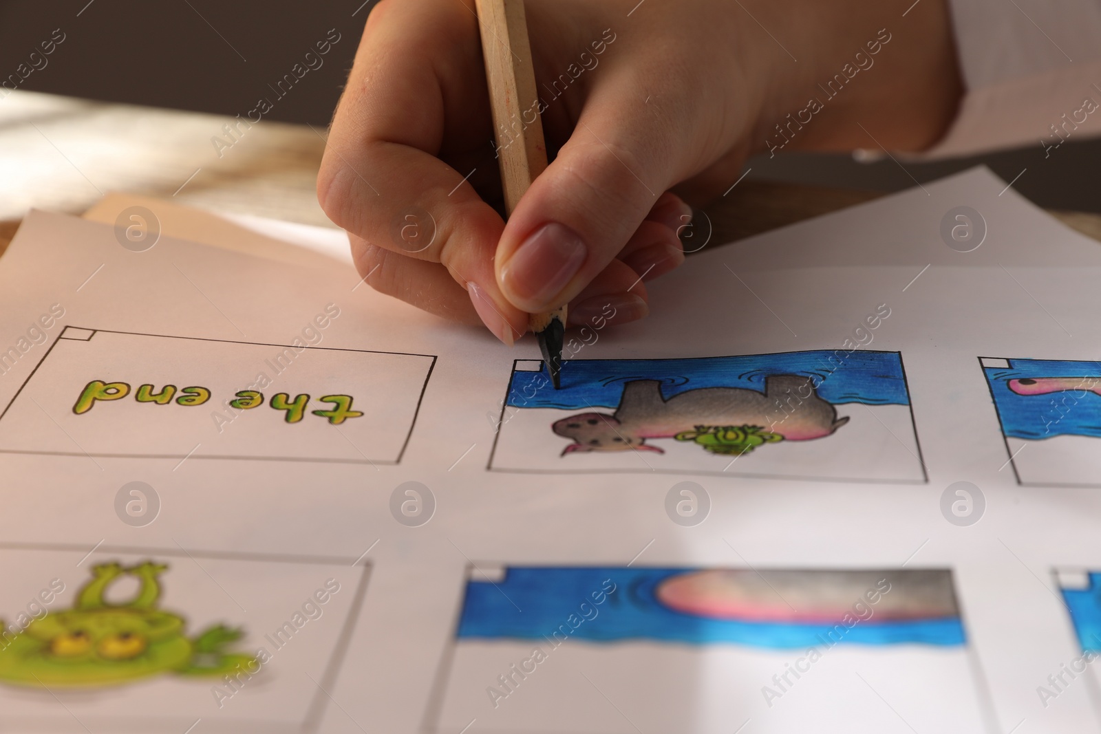 Photo of Woman drawing cartoon sketch in storyboard at workplace, closeup. Pre-production process