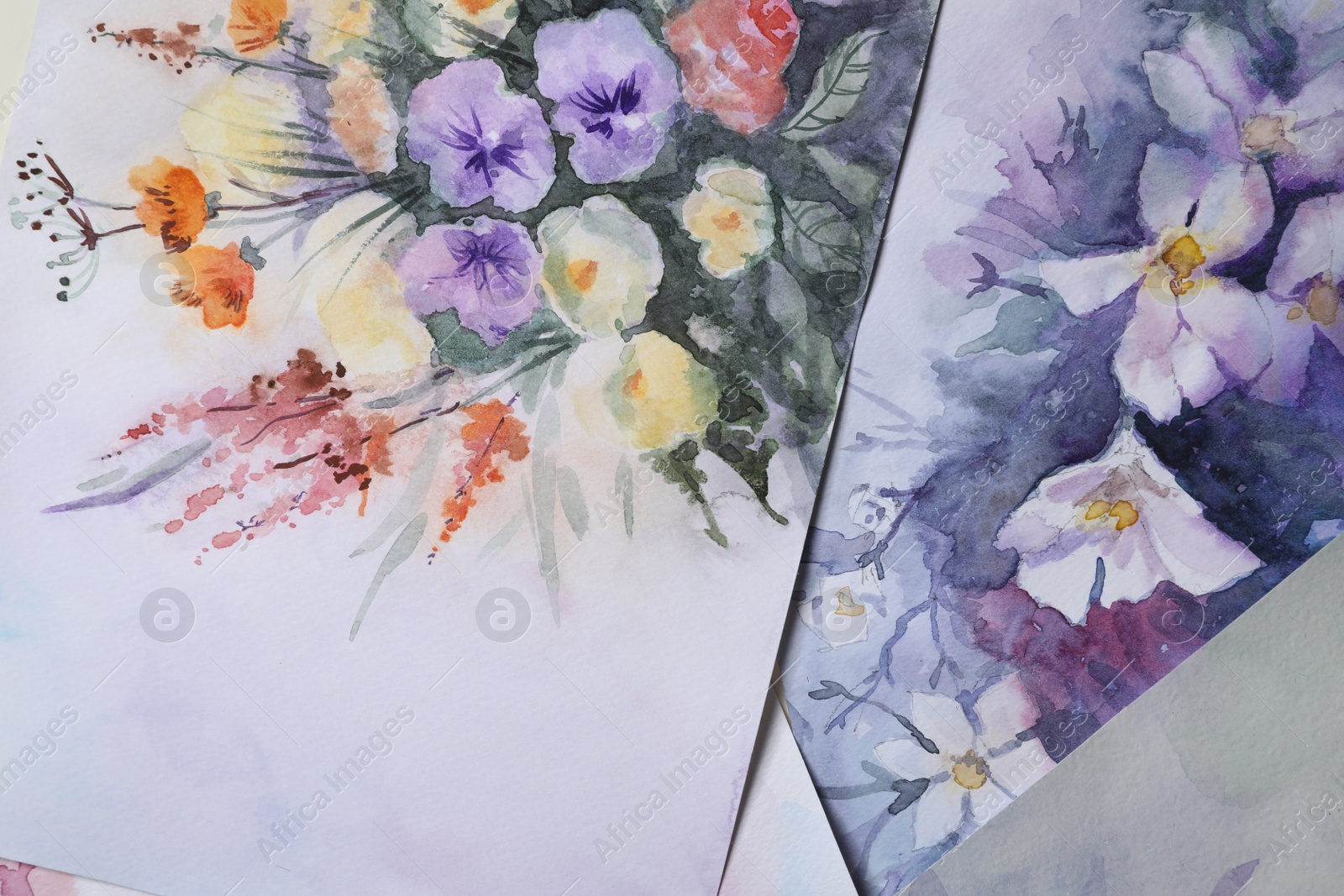 Photo of Paper sheets with beautiful floral watercolor paintings, closeup