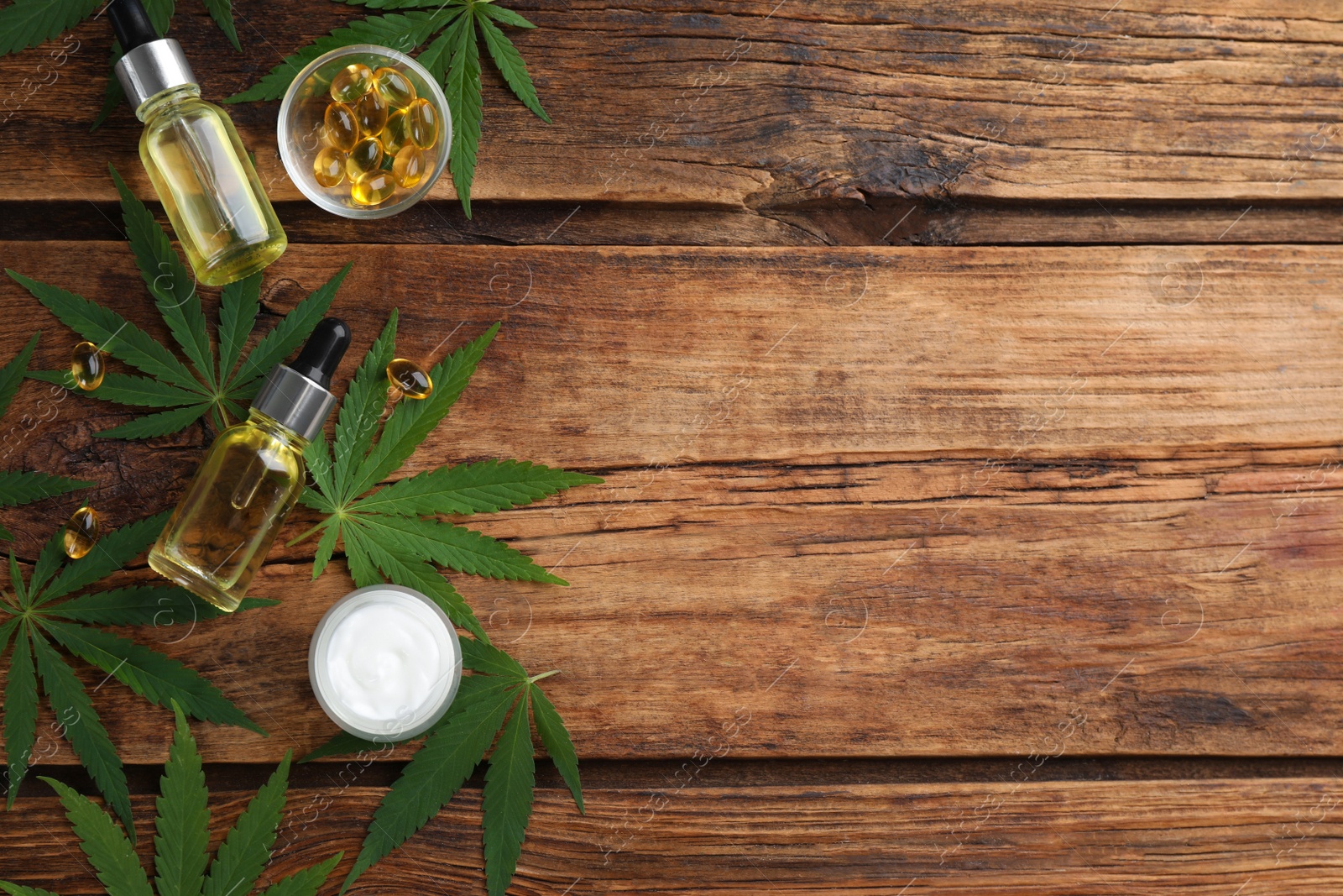 Photo of Composition with CBD oil, THC tincture and hemp leaves on wooden table, flat lay. Space for text