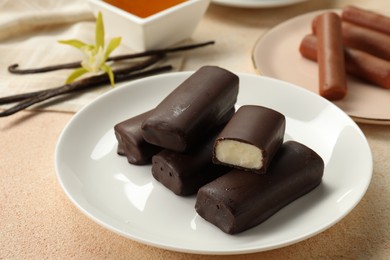 Photo of Glazed vanilla curd cheese bars served on beige table, closeup