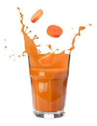 Image of Carrot slices falling into glass of fresh juice with splashes on white background