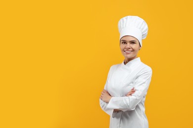 Photo of Happy female chef wearing uniform and cap on orange background. Space for text