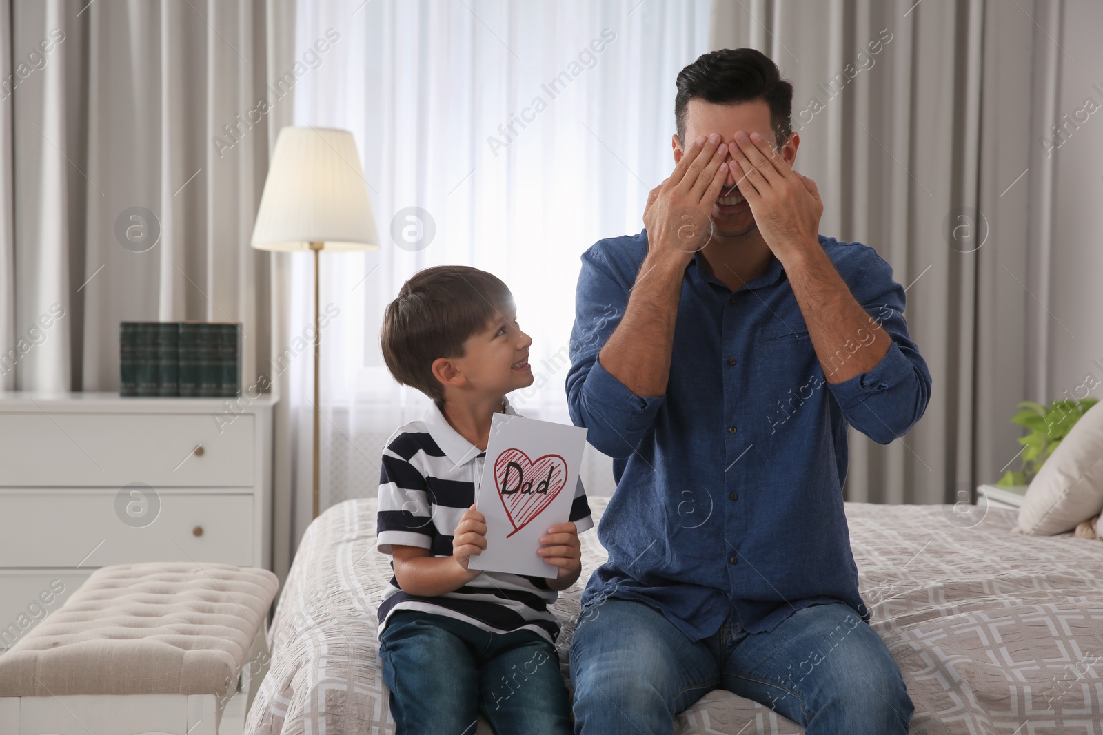 Photo of Little boy greeting his dad with Father's Day at home