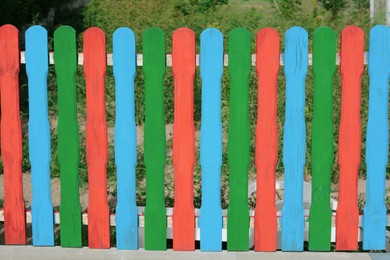 Colorful wooden fence on sunny day outdoors