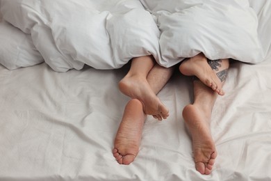 Photo of Passionate couple having sex on bed, closeup of legs
