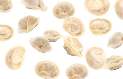 Many tasty dumplings falling on white background