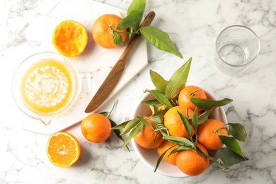 Photo of Flat lay composition with ripe tangerines and juicer on marble background