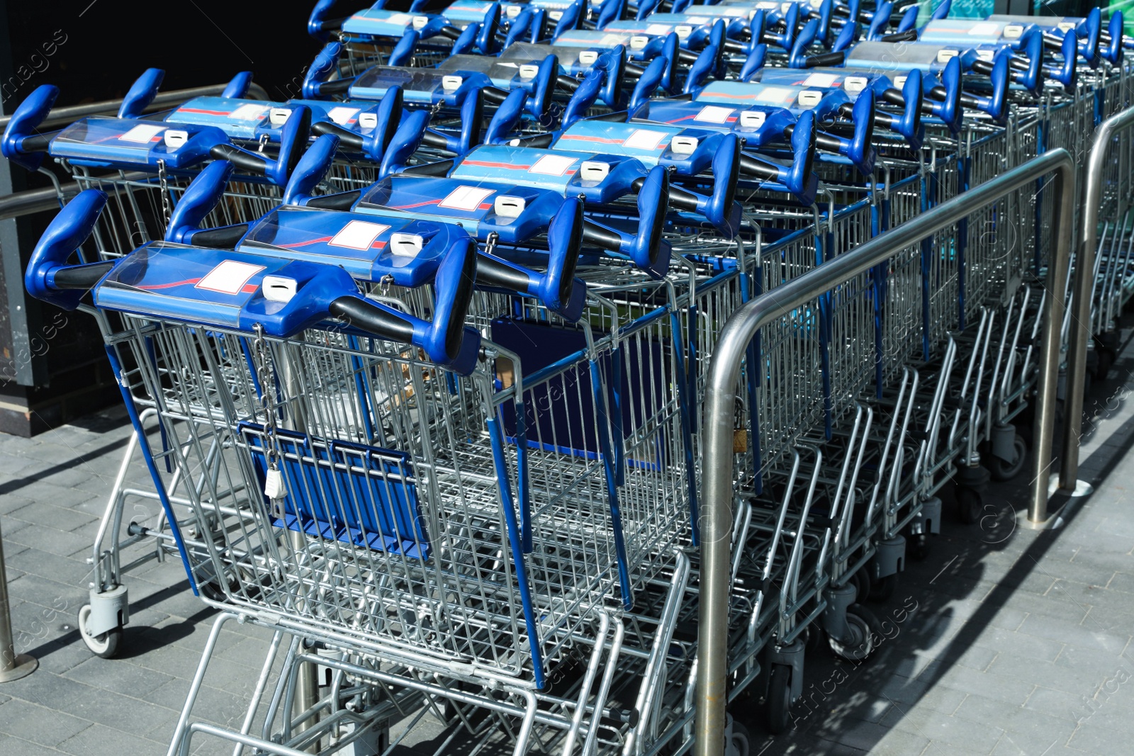 Photo of Many empty shopping carts near supermarket, closeup