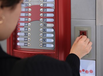 Image of Using coffee vending machine. Woman inserting coin to pay for drink, closeup