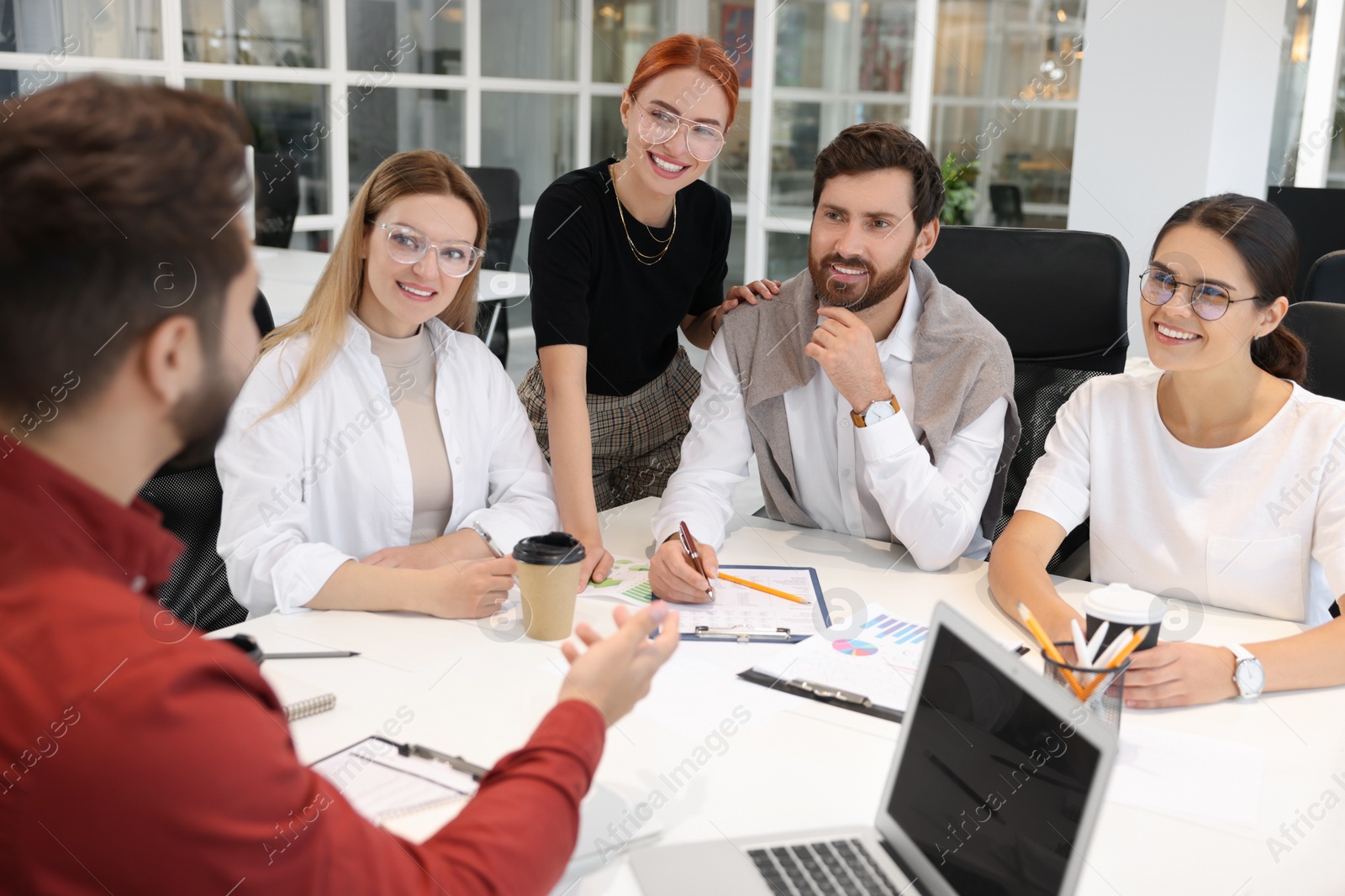 Photo of Team of employees working together in office