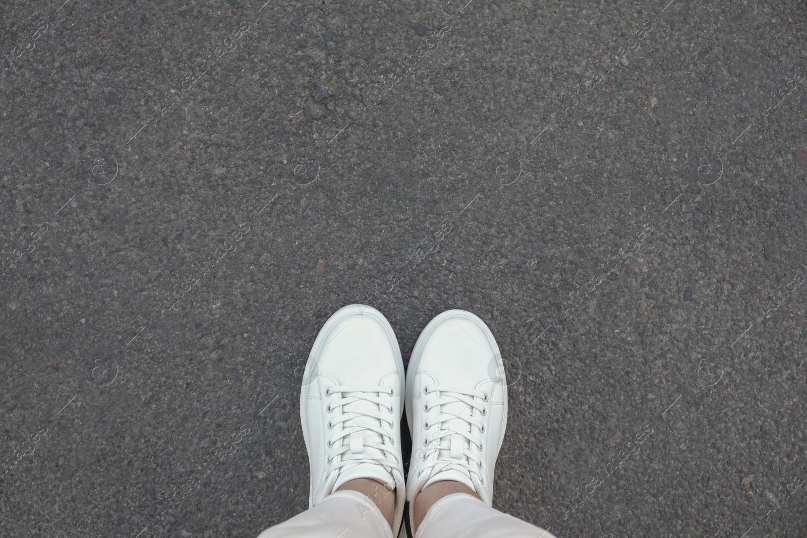 Photo of Woman standing on asphalt, top view. Space for text