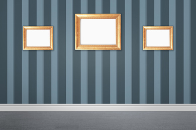 Image of Frames with empty canvases on wall in modern art gallery. Space for design