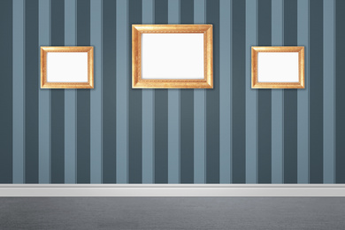 Frames with empty canvases on wall in modern art gallery. Space for design