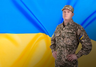 Image of Soldier in military camouflage uniform and Ukrainian flag on background, space for text. Stop war