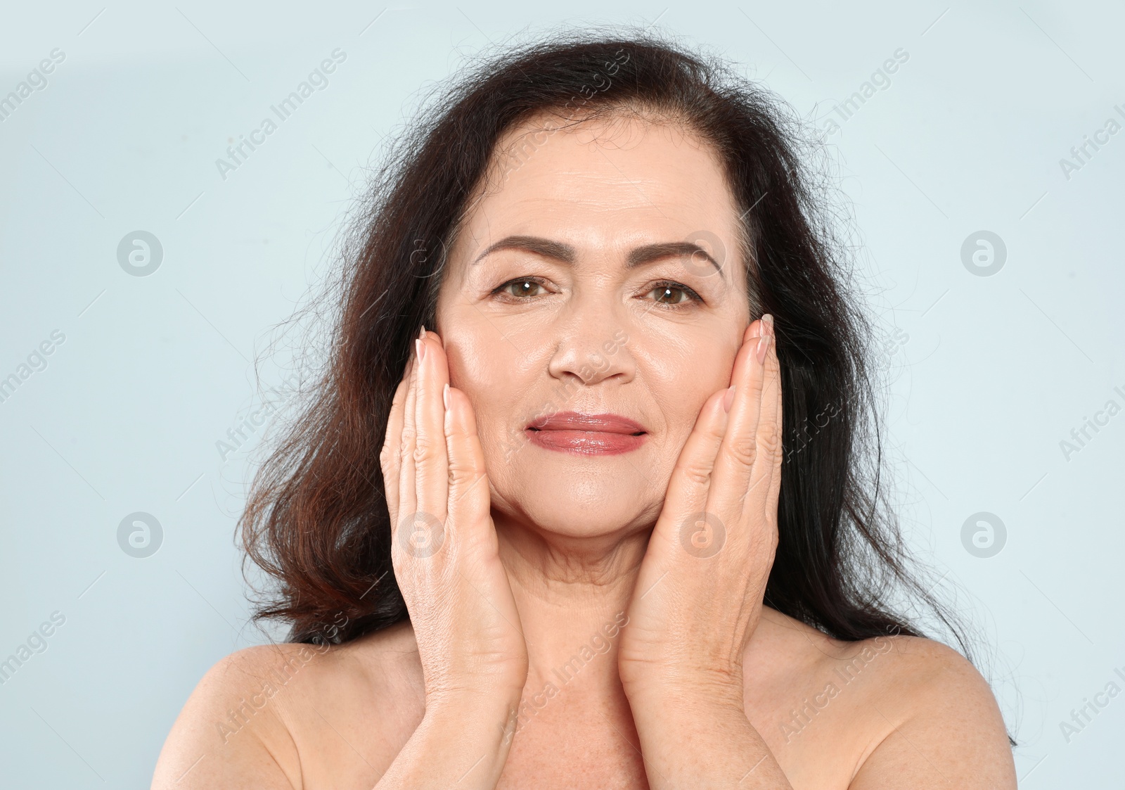 Photo of Portrait of mature woman with beautiful face on grey background