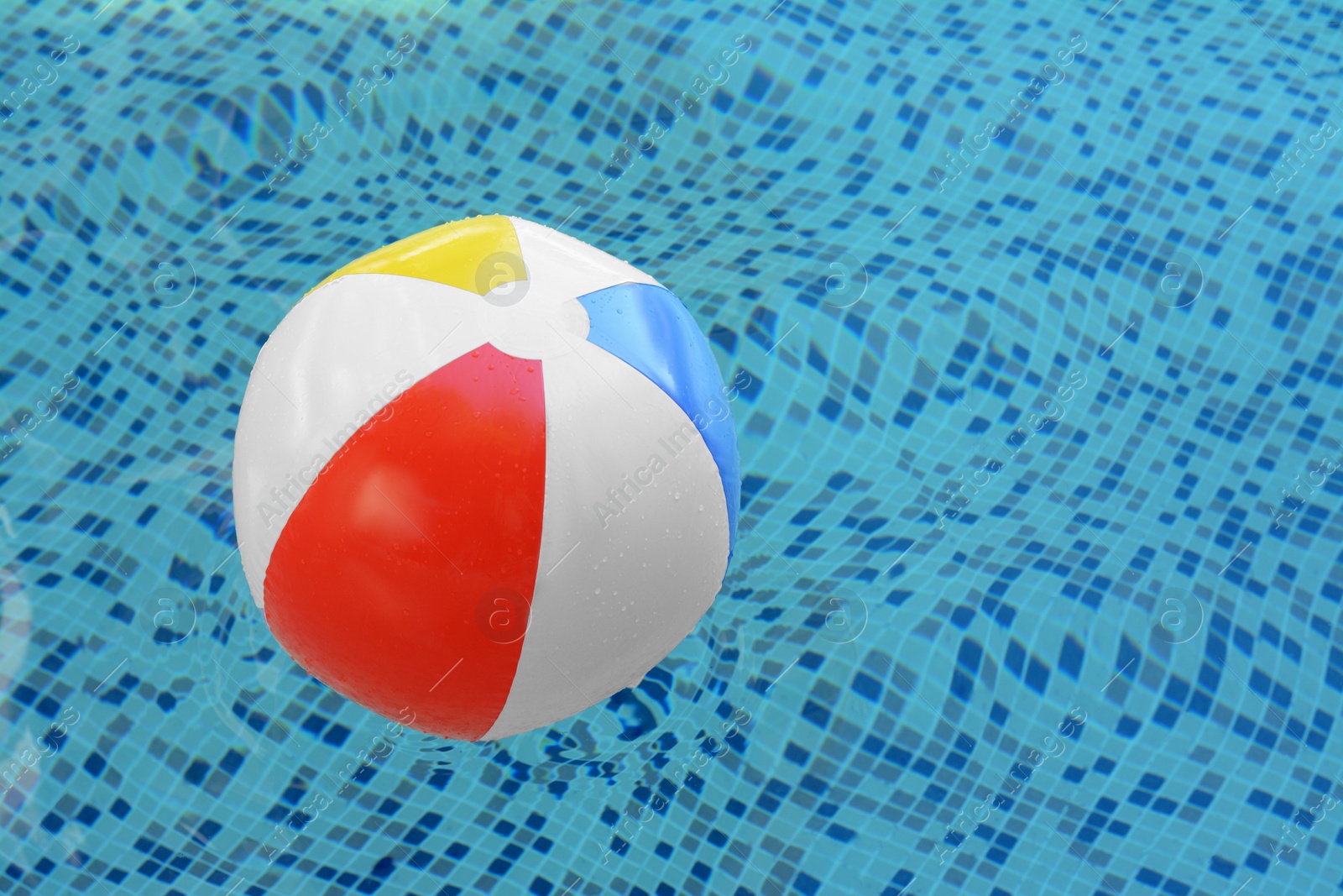 Photo of Inflatable beach ball floating in swimming pool, space for text