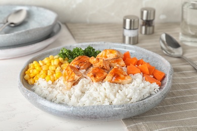 Photo of Plate of boiled rice with vegetables and meat on table