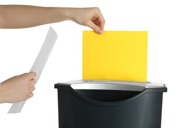 Photo of Woman destroying sheet of yellow paper with shredder on white background, closeup