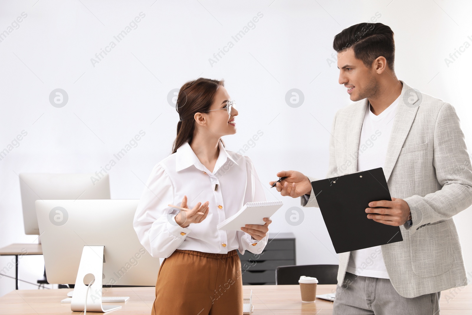 Photo of Businessman helping intern with work in office