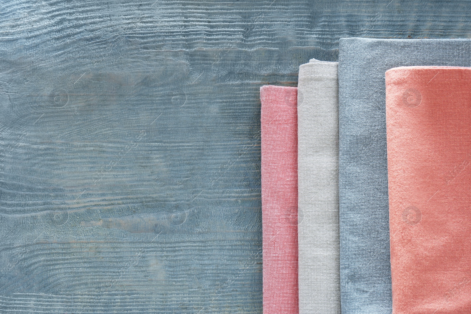 Photo of Different colorful napkins on wooden table, top view. Space for text