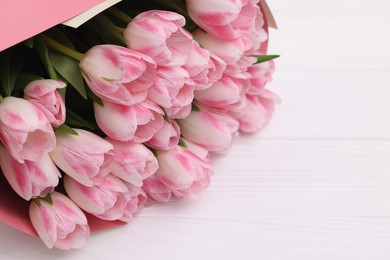 Beautiful bouquet of fresh pink tulips on white wooden table, closeup. Space for text