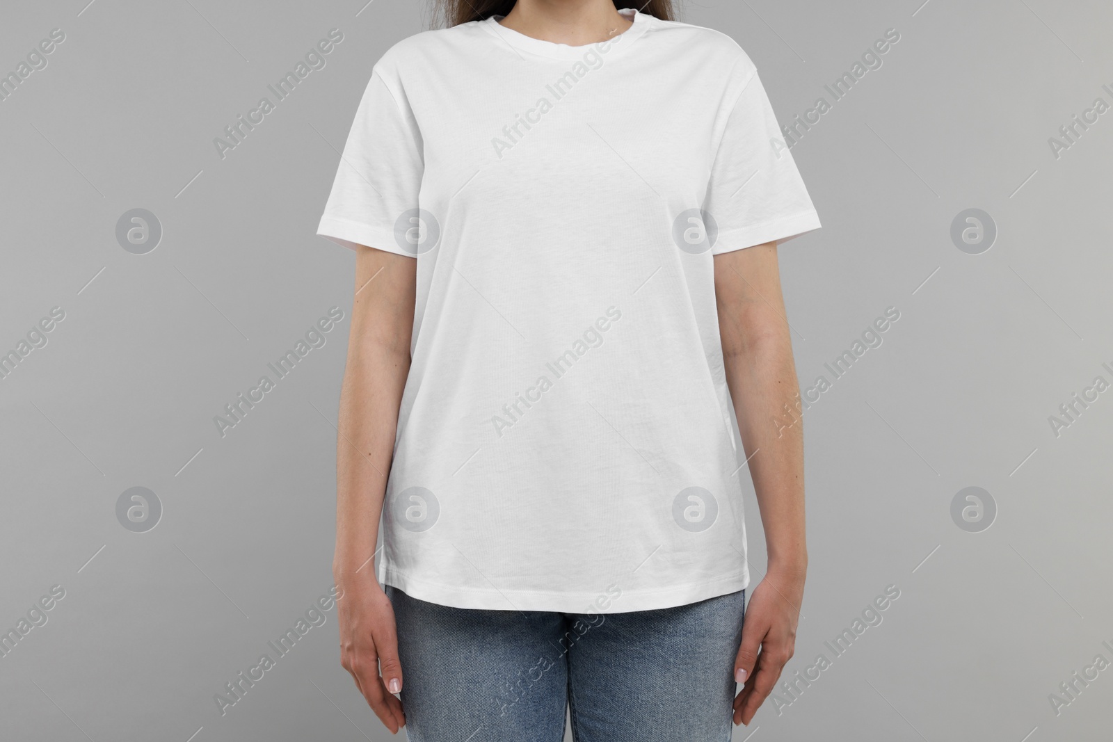 Photo of Woman in white t-shirt on grey background, closeup