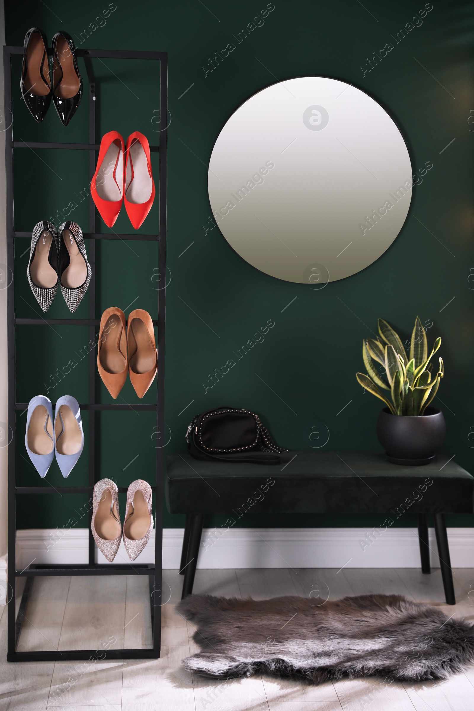 Photo of Hallway interior with storage rack, stylish women's shoes and bench