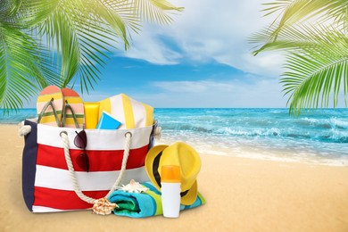 Image of Stylish bag with different accessories on tropical sandy beach, space for text 