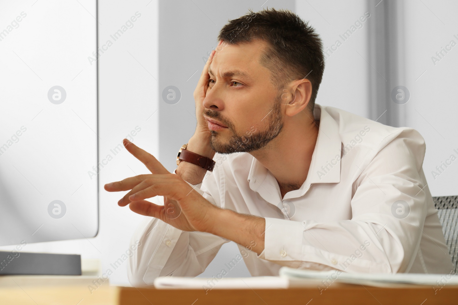 Photo of Sleep deprived man at workplace in office