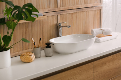 Stylish vessel sink near wooden wall in modern bathroom