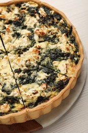 Delicious homemade spinach quiche on white table, closeup