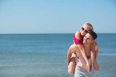 Photo of Happy young couple having fun at beach on sunny day