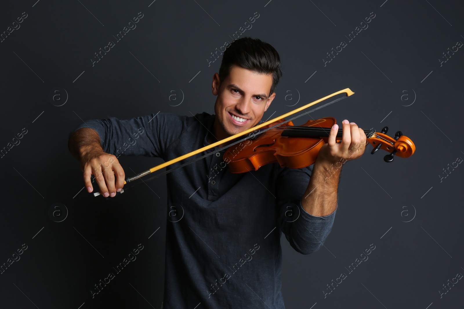 Photo of Happy man playing violin on black background