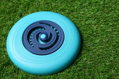 Photo of Light blue plastic frisbee disk on green grass