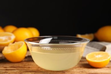 Freshly squeezed lemon juice in glass bowl on wooden table