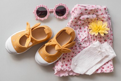 Photo of Stylish child clothes, shoes and accessories on grey background, flat lay