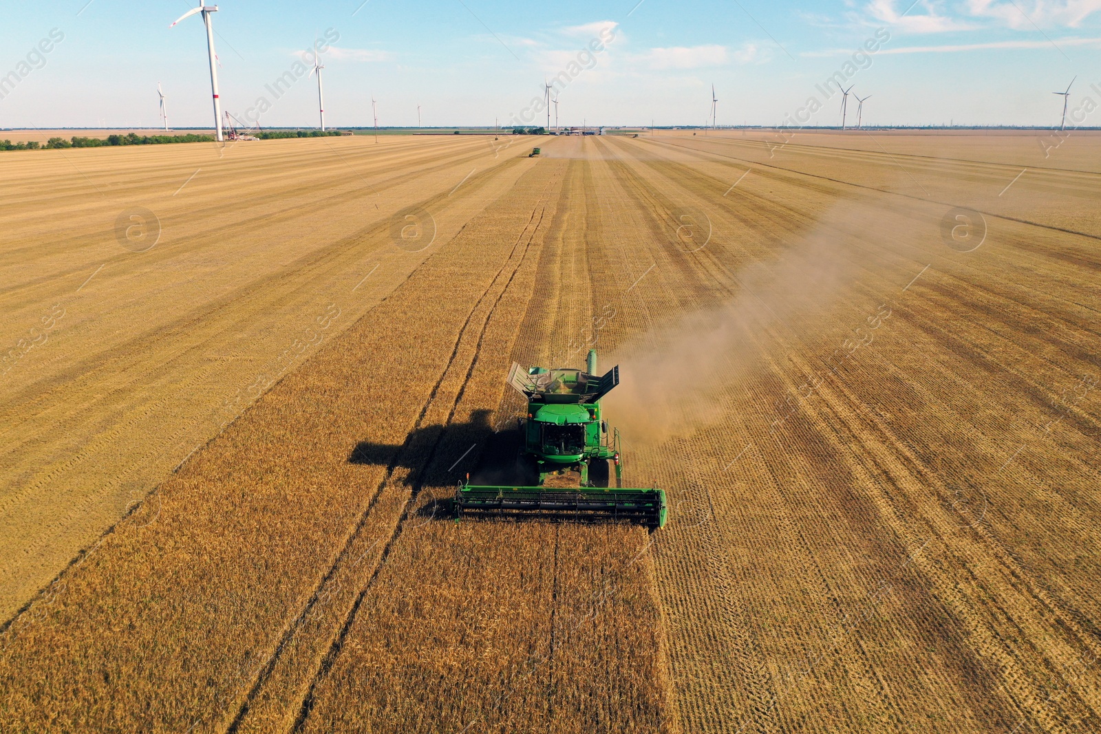 Photo of Modern combine harvester working in field on sunny day. Agriculture industry