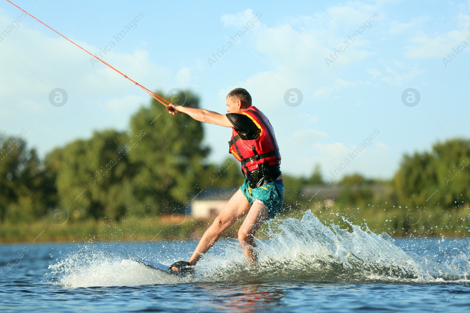 Photo of Man wakeboarding on river. Extreme water sport