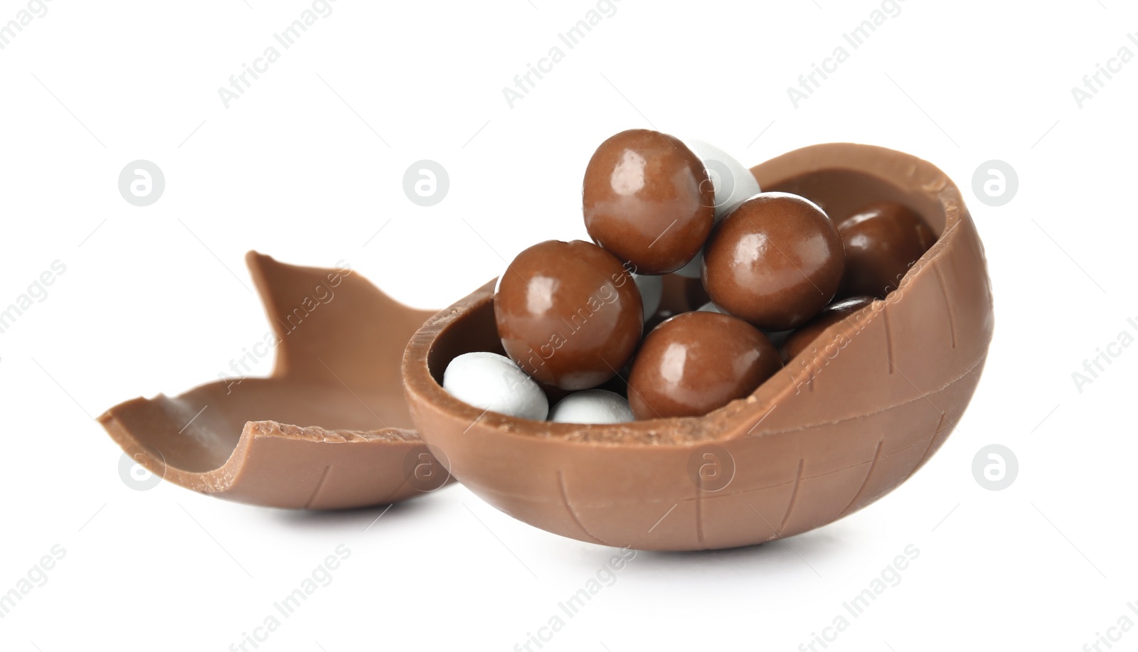 Photo of Broken chocolate egg with candies on white background