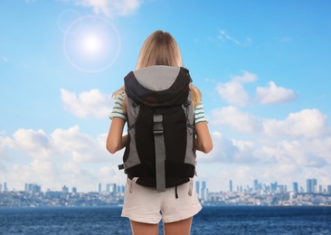 Image of Traveler with backpack near sea during summer vacation trip, back view
