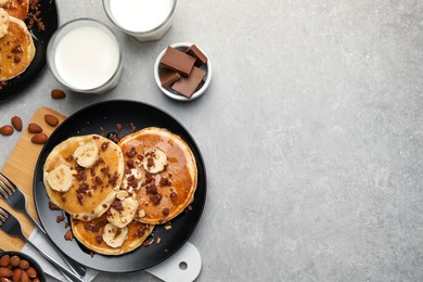 Photo of Tasty pancakes with sliced banana served on light grey table, flat lay. Space for text