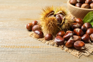 Fresh sweet edible chestnuts on wooden table