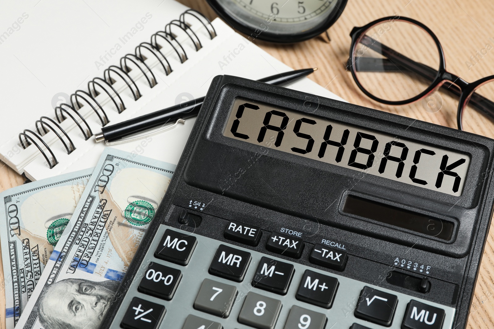 Image of Calculator with word Cashback, money, notebook and glasses on wooden table, closeup